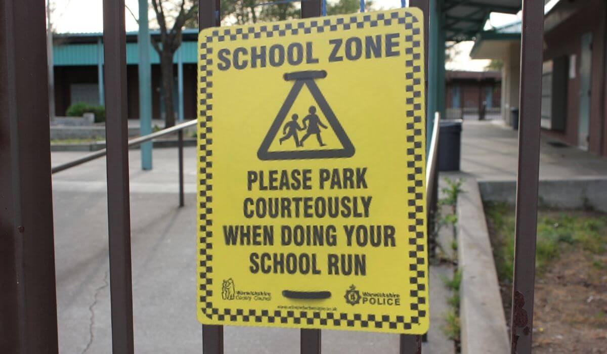 A sign telling parents to park courteously when doing their school run.