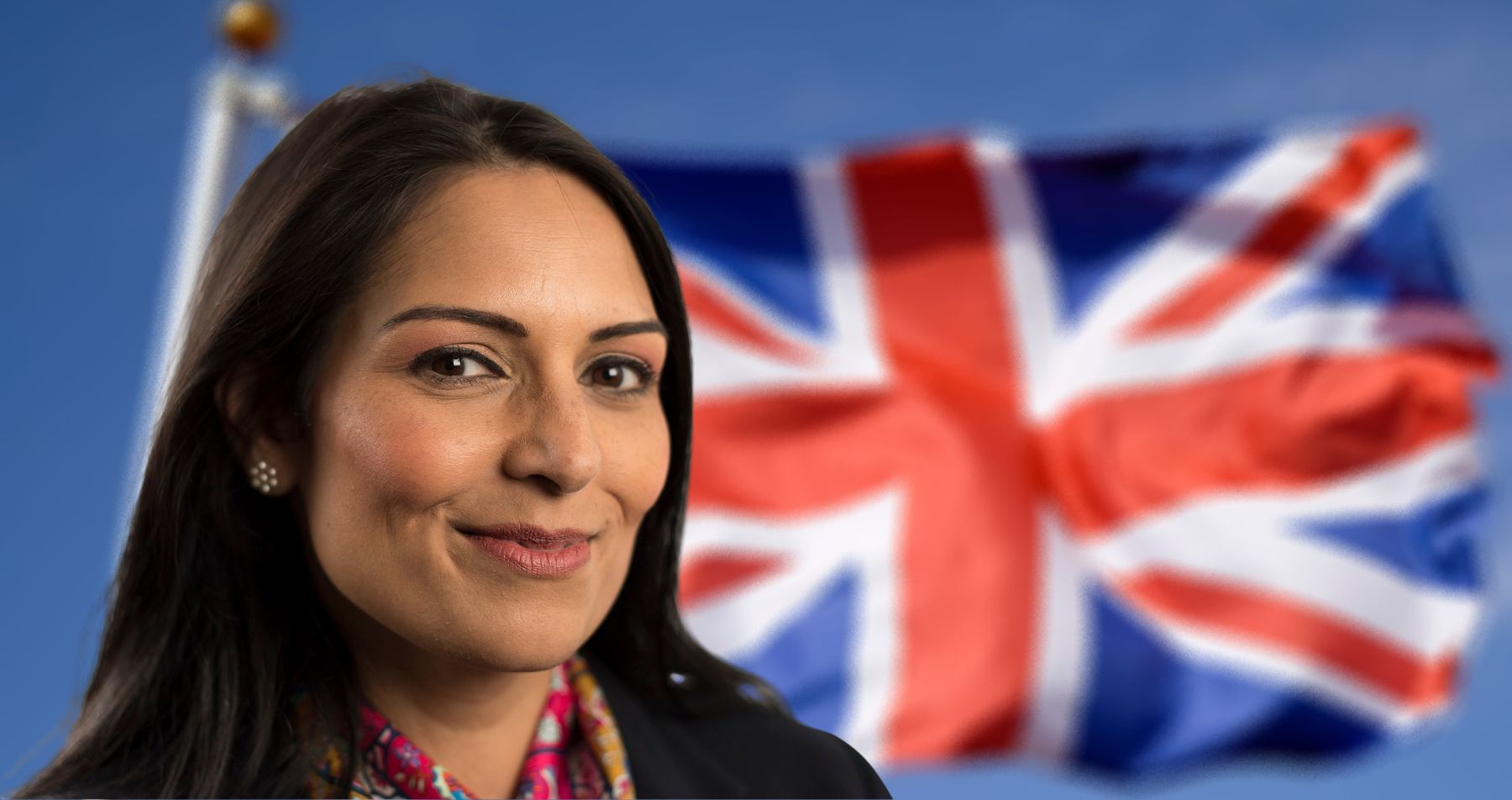 Priti Patel, smirking next to a union flag
